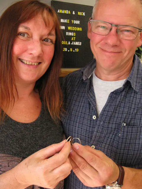 Amanda and Nick holding the wedding rings they made at Orla James