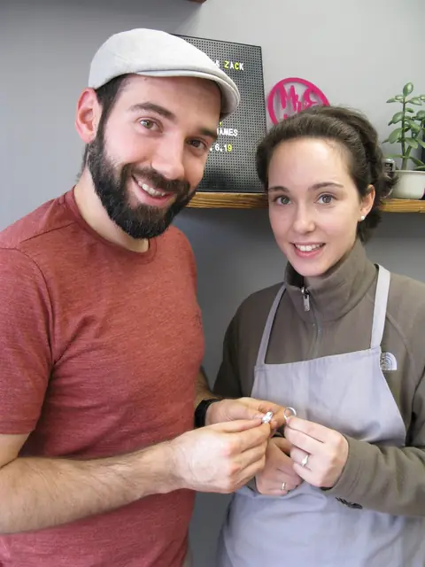 Cassie and Zack holding the wedding rings they made at Orla James