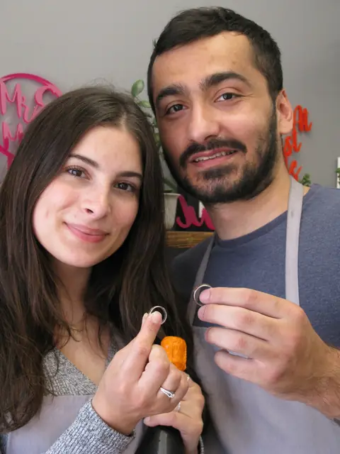 Ela and Gokhan holding the wedding rings they made at Orla James