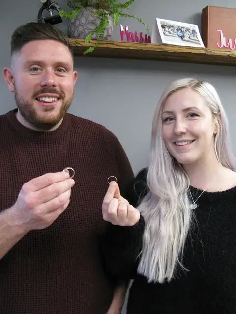 Elicia and Sam holding the wedding rings they made at Orla James