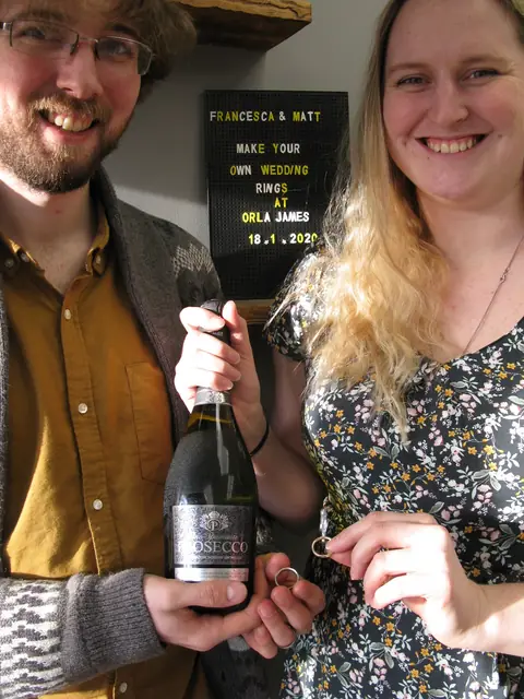 Francesca and Matt holding the wedding rings they made at Orla James