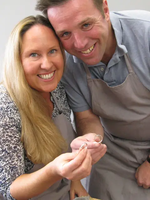 Lisa and Andrew holding the wedding rings they made at Orla James