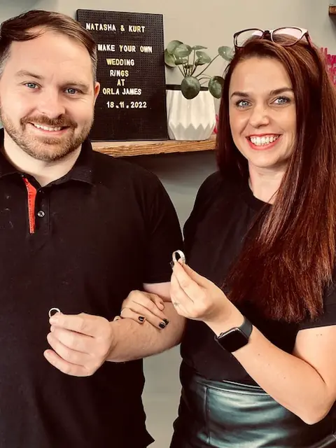 Natasha and Kurt holding the wedding rings they made at Orla James