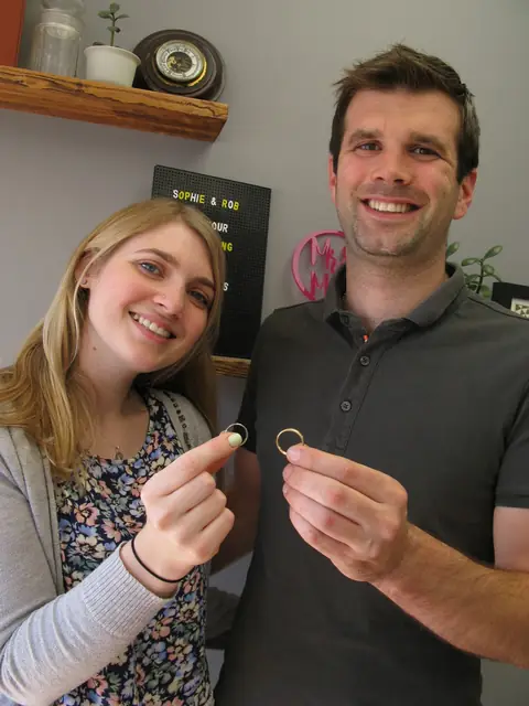 Sophie and Rob holding the wedding rings they made at Orla James