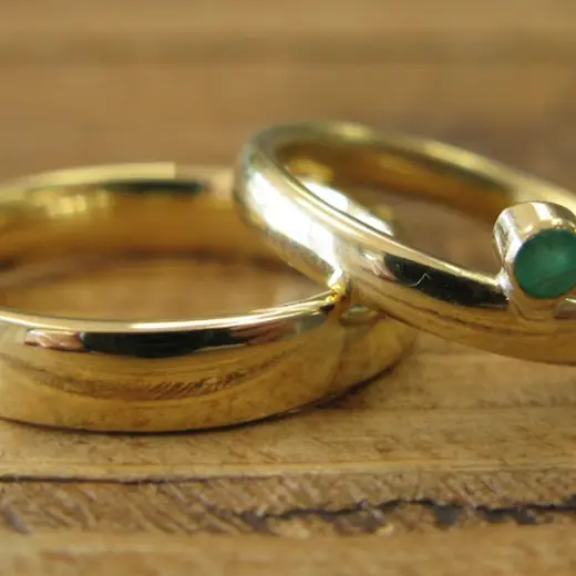 Gold wedding band with a flush-set green gemstone